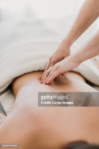 a massage therapist works on a female patient's back - hand massage stock pictures, royalty-free photos & images