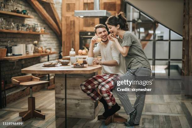 glückliches paar mit spaß während der frühstückszeit zu hause. - couple breakfast stock-fotos und bilder