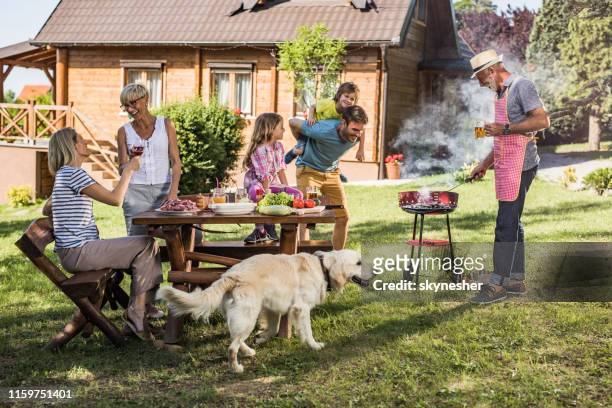 happy extended familie genieten in de barbecue partij in de achtertuin. - backyard picnic stockfoto's en -beelden