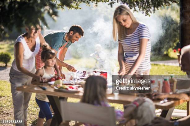 glücklicher mann bereitet grill für die gartenparty seiner familie im hinterhof. - asian person bbq stock-fotos und bilder