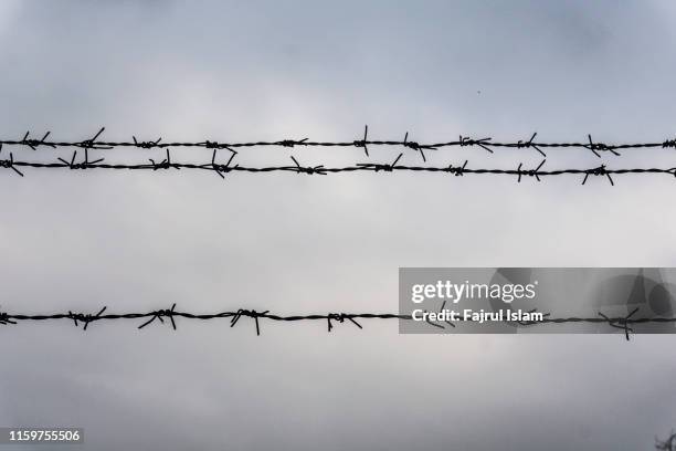 barbed wire against sky - combat libre fotografías e imágenes de stock