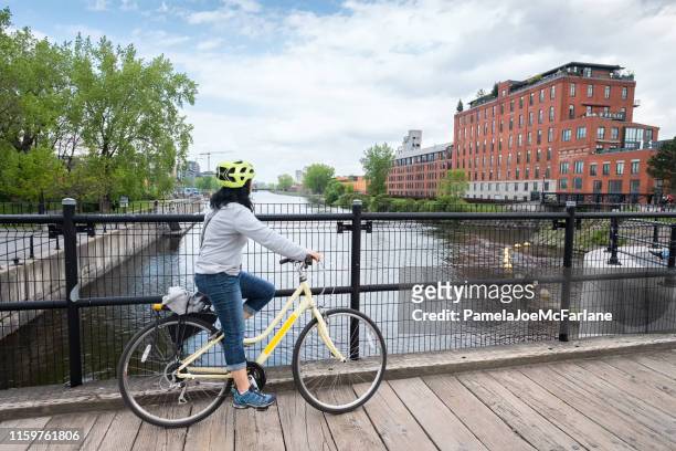 asian woman cyclist enjoying view of lachine canal, montreal, quebec - montréal stock pictures, royalty-free photos & images