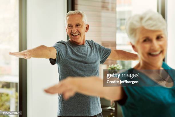 regelmäßige bewegung reduziert das risiko chronischer krankheiten - senior yoga stock-fotos und bilder