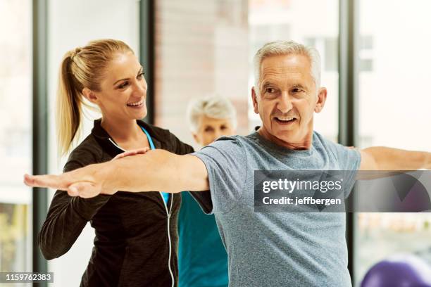 staying balanced in his elderly years - yoga instructor stock pictures, royalty-free photos & images