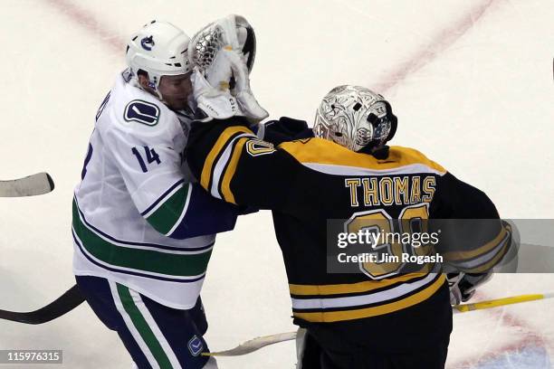 Tim Thomas of the Boston Bruins fights with Alex Burrows of the Vancouver Canucks during Game Four of the 2011 NHL Stanley Cup Final at TD Garden on...