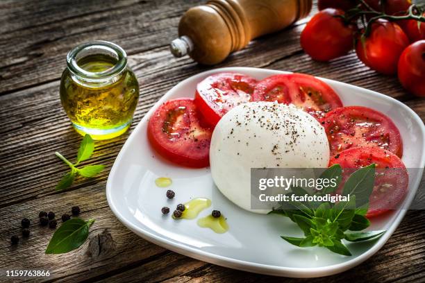 healthy fresh burrata cheese salad on rustic wooden table - mozzarella stock pictures, royalty-free photos & images