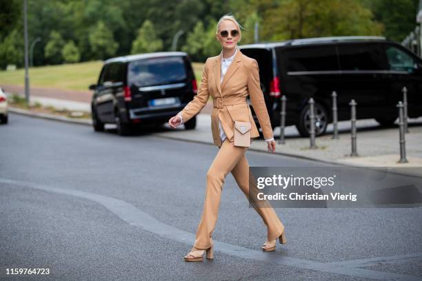 Kate Gelinsky is seen wearing total look Marc Cain brown suit pants and blazer, bag, white button shirt, sandals during Mercedes Benz Fashion Week...