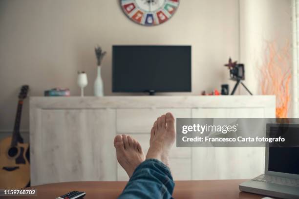 man watching tv .pov - feet up - fotografias e filmes do acervo