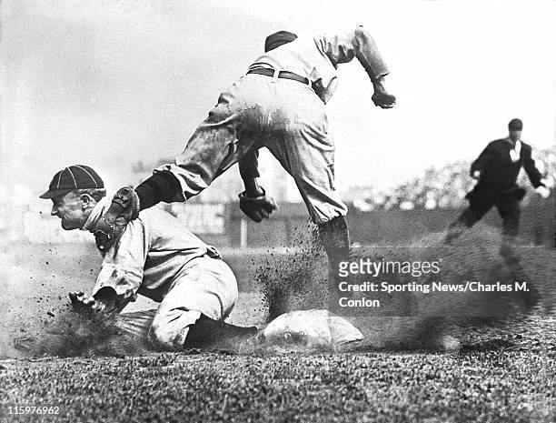 Outfielder Ty Cobb of the Detroit Tigers slides safely into third base as third baseman Jimmy Austin of the New York Yankees misses the throw from...