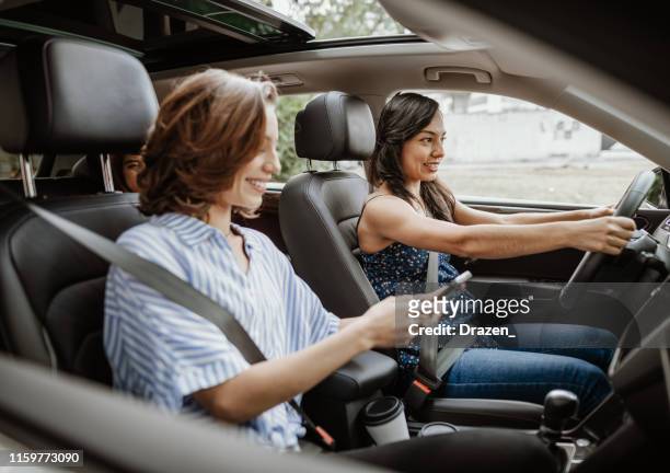passengers in ride sharing helping driver with gps navigation - car sharing stock pictures, royalty-free photos & images