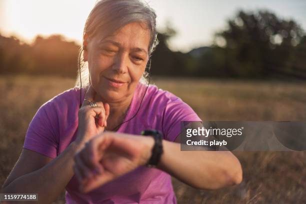運動後の脈拍をチェックするシニア女性 - 心臓刺激伝導系 ストックフォトと画像