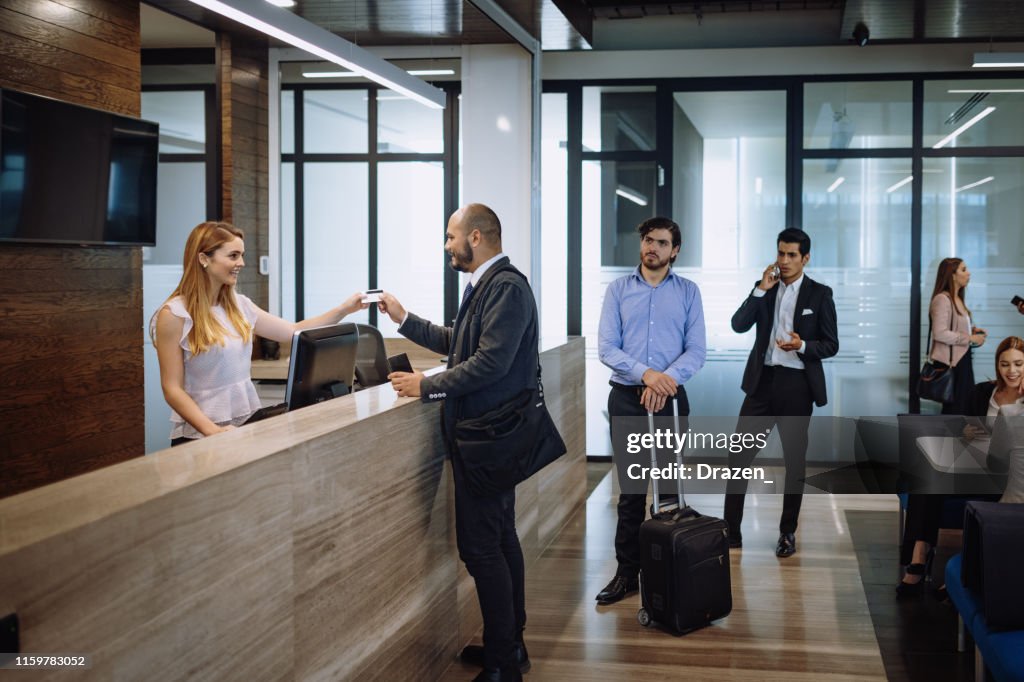 Business travelers checking in luxury hotel