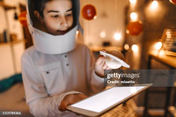 boy in the role of an astronaut with digital tablet - space helmet stock pictures, royalty-free photos & images