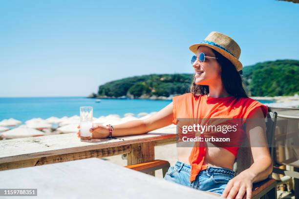 woman drinking on beach terrace - ouzo stock pictures, royalty-free photos & images