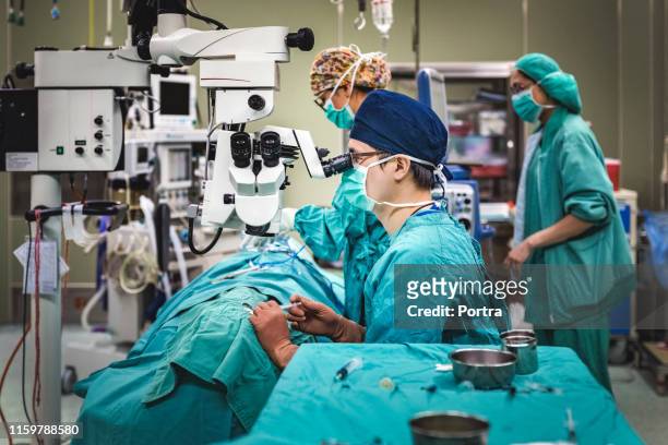 doctors performing surgery on patient in icu - eye doctor stock pictures, royalty-free photos & images
