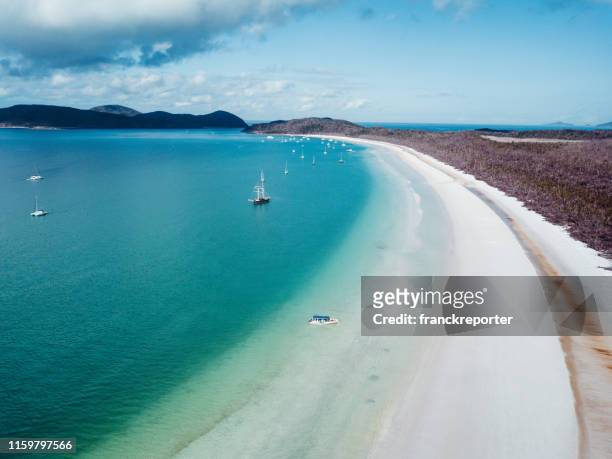 whitsunday beach with a boat - airlie beach stock pictures, royalty-free photos & images