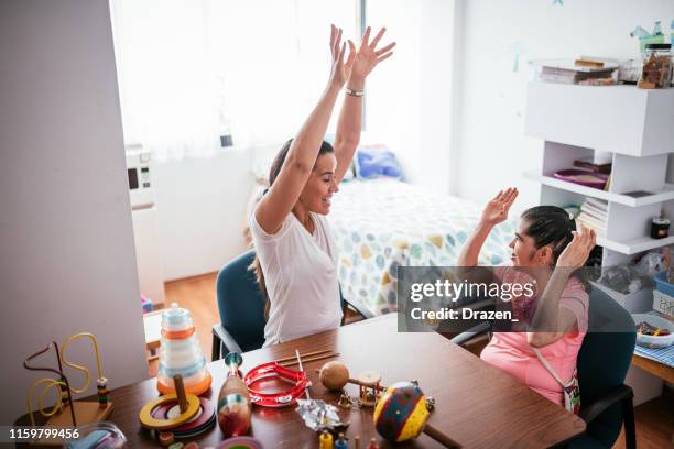 woman born with down syndrome singing together with teacher in nursery - learning disability nurse stock pictures, royalty-free photos & images