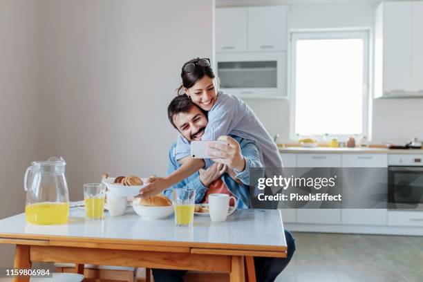 joyful man and woman taking selfie - valentine's day home stock pictures, royalty-free photos & images