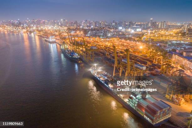 logistics and transportation of container cargo ship and cargo with working crane bridge in shipyard at sunrise, logistic import export and transport industry background - singapore port stock pictures, royalty-free photos & images