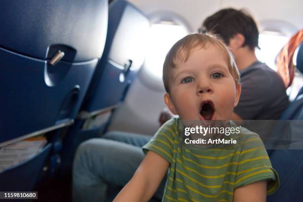naughty boy travelling by plane - embarrased dad stock pictures, royalty-free photos & images
