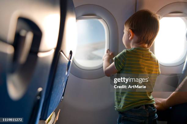 child travelling by plane - passenger window stock pictures, royalty-free photos & images
