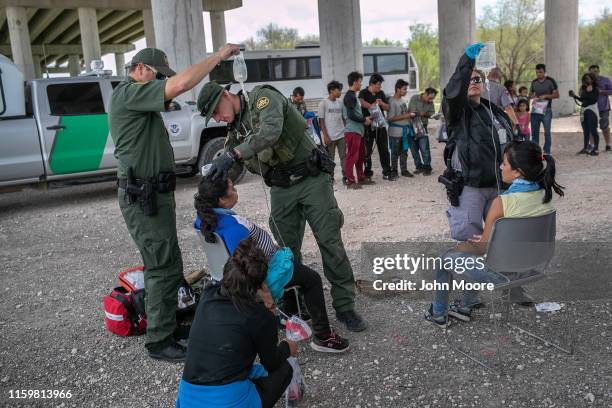 Border Patrol medic treats an immigrant for heat exhaustion after taking her into custody on July 02, 2019 in McAllen, Texas. The immigrants, mostly...