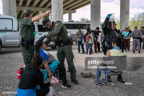 Border Patrol medic treats an immigrant for heat exhaustion after taking her into custody on July 02, 2019 in McAllen, Texas. The immigrants, mostly...
