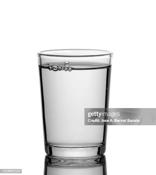 shot glass filled with water isolated on white. - glass water foto e immagini stock