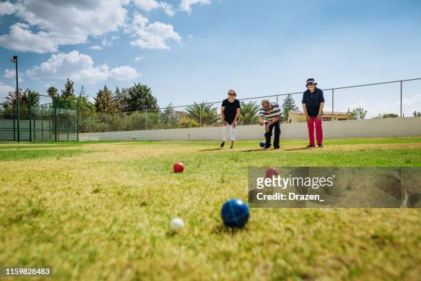 latino senior people playing boules - bocce ball stock pictures, royalty-free photos & images
