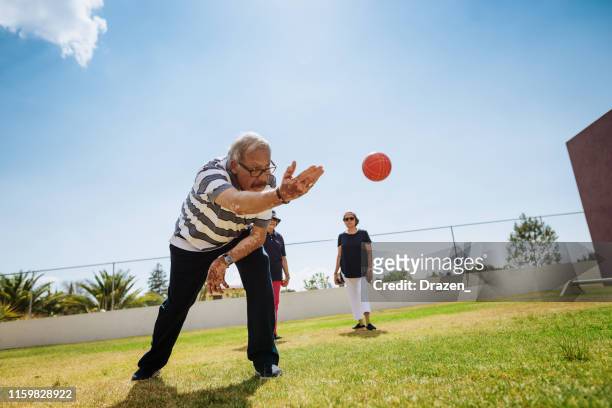 hispanic senior man playing boules with ladies. - bocce ball stock pictures, royalty-free photos & images