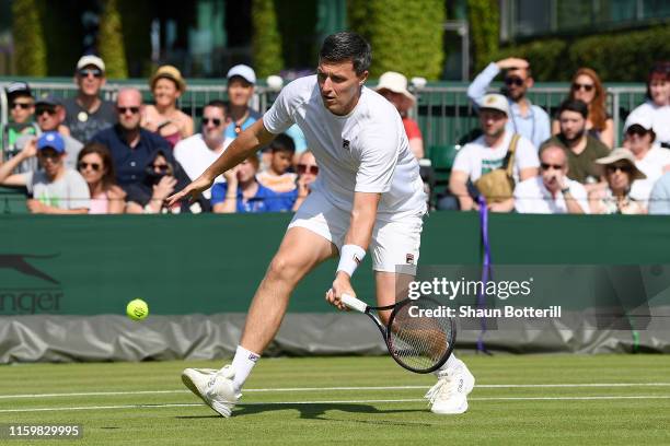 Ken Skupski of Great Britain, partner of John-Patrick Smith of Australia plays a backhand in their Men's Doubles first round match against Jay Clarke...