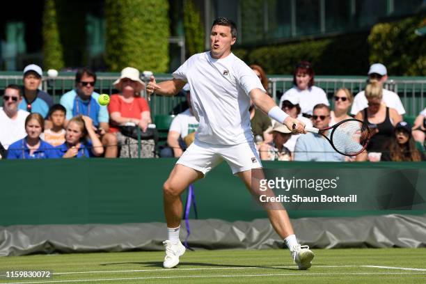 Ken Skupski of Great Britain, partner of John-Patrick Smith of Australia plays a backhand in their Men's Doubles first round match against Jay Clarke...