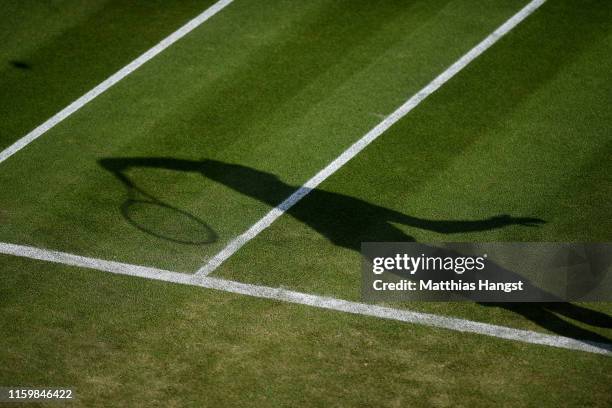 The shadow of Janko Tipsarevic of Serbia is seen as he serves in his Men's Singles second round match against Kevin Anderson of South Africa during...