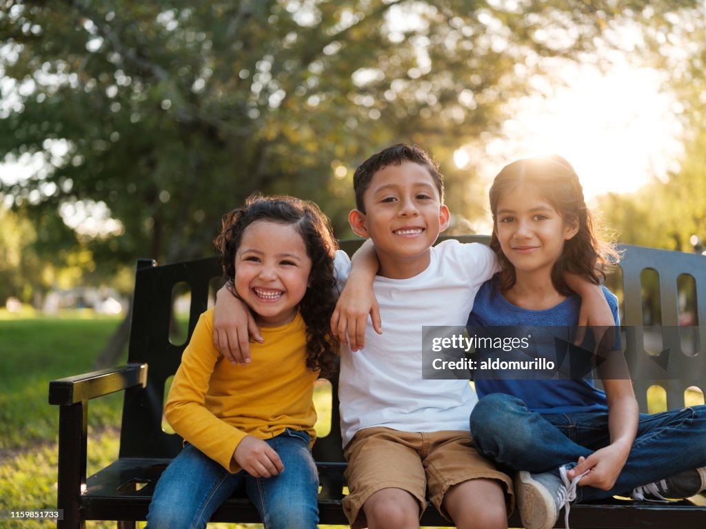 Hermanos felices lado a lado en el parque