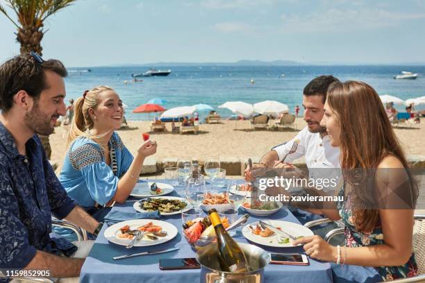 vrienden genieten van zeevruchten en wijn aan de costa brava restaurant - provincie barcelona stockfoto's en -beelden