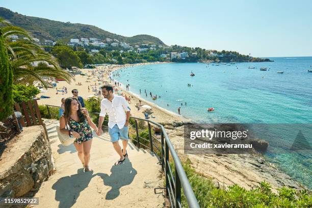 jeunes couples romantiques appréciant la vue de la plage de brava de costa - province-de-barcelone photos et images de collection