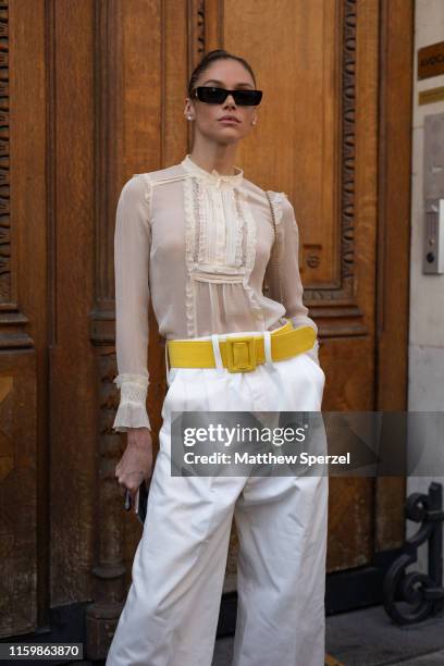 Guest is seen on the street during Paris Fashion Week Haute Couture wearing sheer shirt, yellow belt and white pants on July 03, 2019 in Paris,...