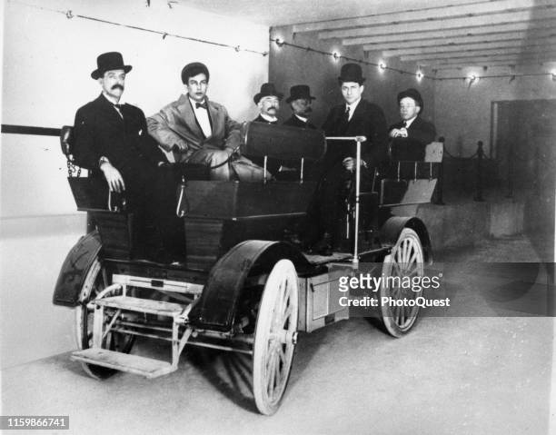 View of a group of unidentified US Senators and staff members as they sit in an electric Studebaker car in the tunnel that links the Russell Senate...