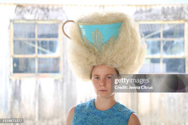 a lady with big hair with a big teacup in it - kopfschutz stock-fotos und bilder