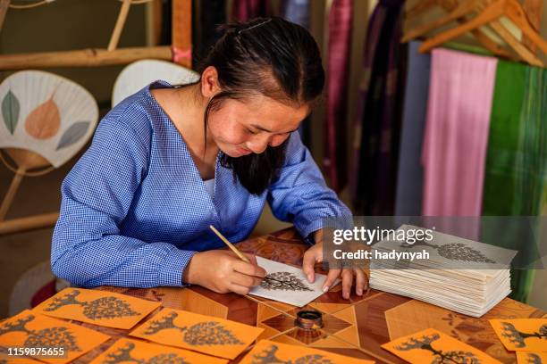 laotische junge mädchen malerei postkarten in einer werkstatt, luang prabang, laos - laos vientiane stock-fotos und bilder