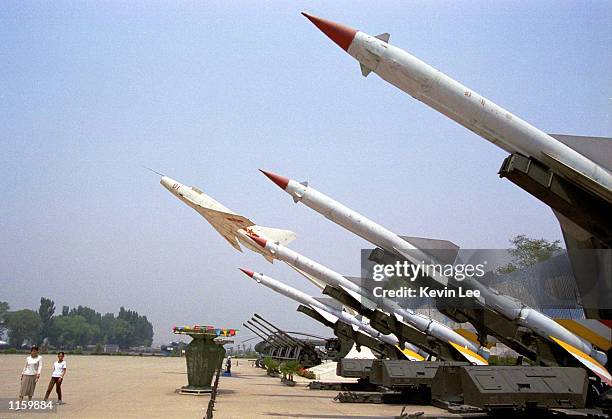 Locals walk past Chinese missiles named "Red Flag Number Three" at the Aircraft Museum May 12, 2001 in Beijing. Chinese and American officials are...