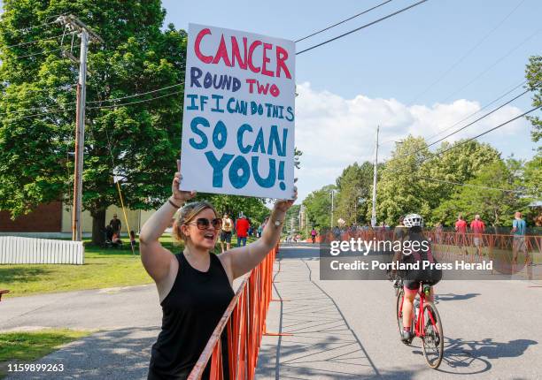 LLynne Patel, a cancer survivor who intended on competing, but needed surgery recently when her melanoma returned, cheers on participants in the Tri...