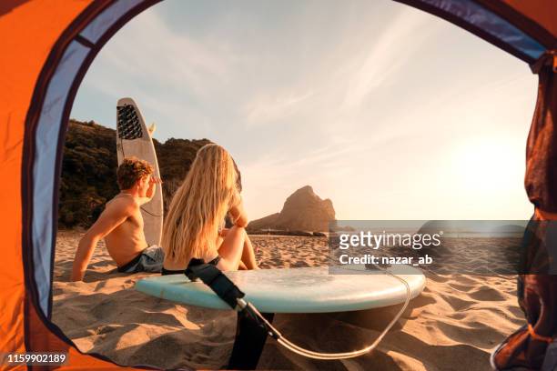 ビーチで夕日を楽しむテントからのサーファーの眺め。 - australia v new zealand ストックフォトと画像
