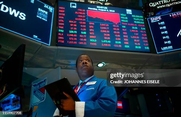 Traders work on the floor at the New York Stock Exchange on August 5, 2019 at Wall Street in New York City. - Wall Street stocks plunged after a...