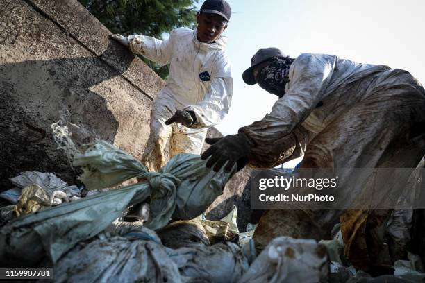 Workers load sand affected by an oil spill at a shoreline onto a truck in Karawang, West Java, Indonesia, August 4, 2019. Indonesias PT Pertamina has...
