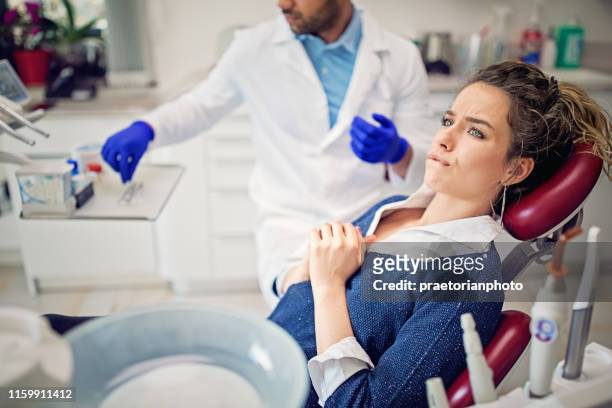 porträt eines verängstigten jungen mädchens in der zahnarztpraxis - verängstigt stock-fotos und bilder