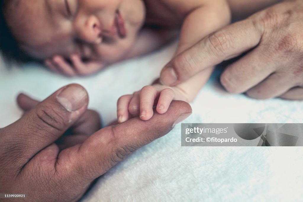 Baby holding parents hands