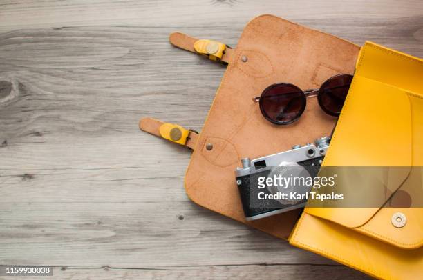 travel concept flat lay of yellow leather bag, camera and sunglasses - sunglasses overhead fotografías e imágenes de stock