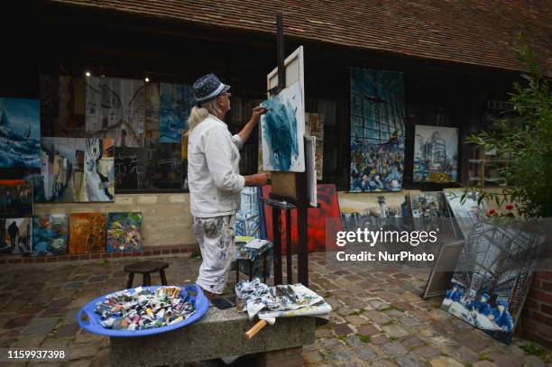 An artist paints on the main street in Beuvron-en-Auge. On Friday, August 2 in Caen, Normandy, France.