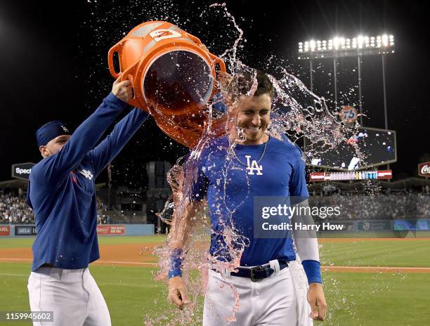 Cody Bellinger of the Los Angeles Dodgers reacts as he has Gatorade dumped over him by Alex Verdugo and Edwin Rios, after his walk off solo homerun...